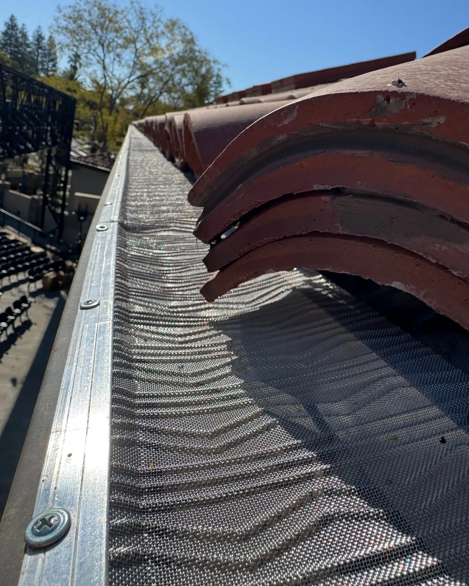 Close-up of a micro-mesh gutter guard fastened to a Sacramento home's tile roofline