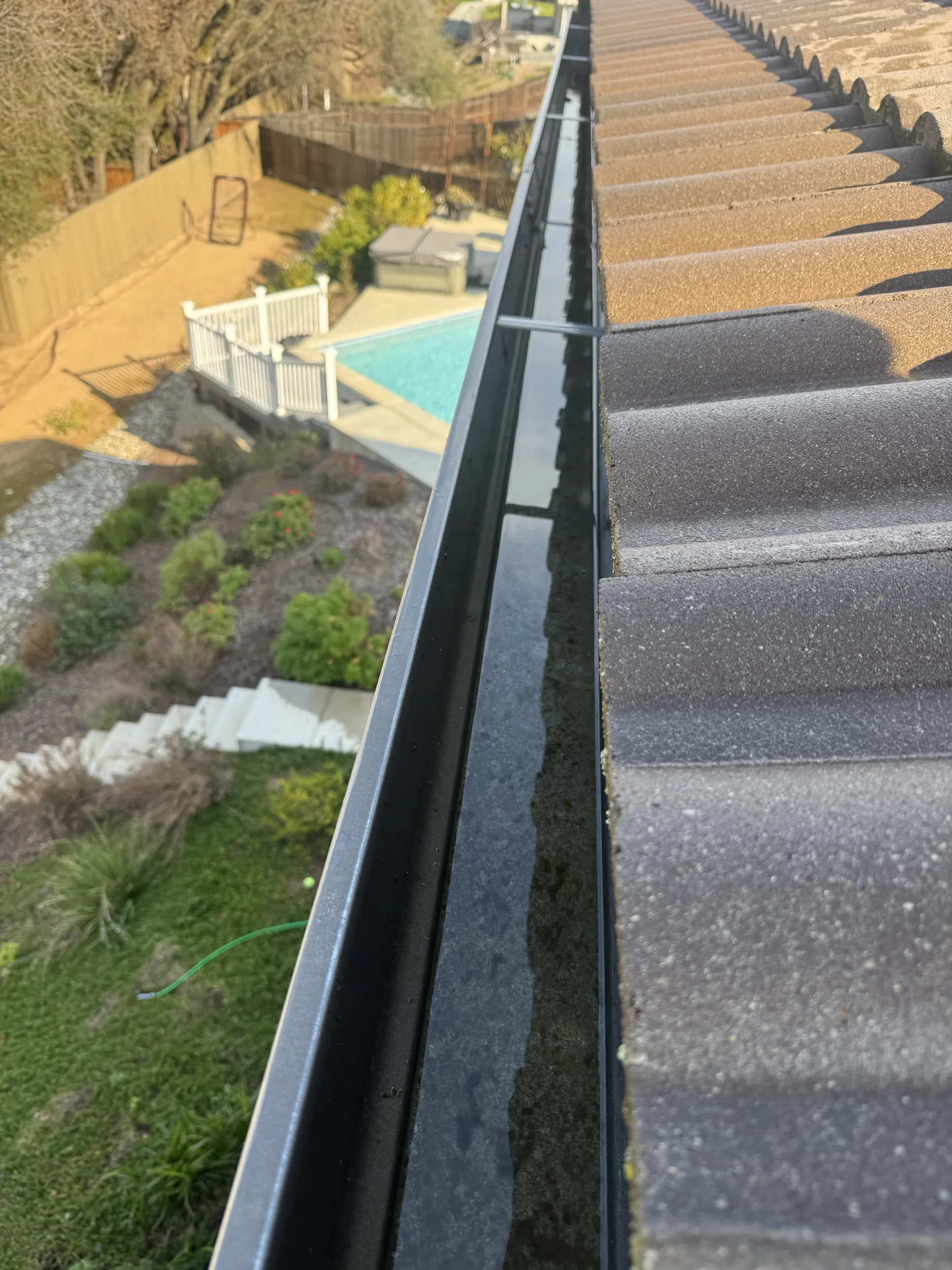 The same Sacramento home's gutter and tile roofline, clear and clean after a Dunzo Gutters roof cleaning