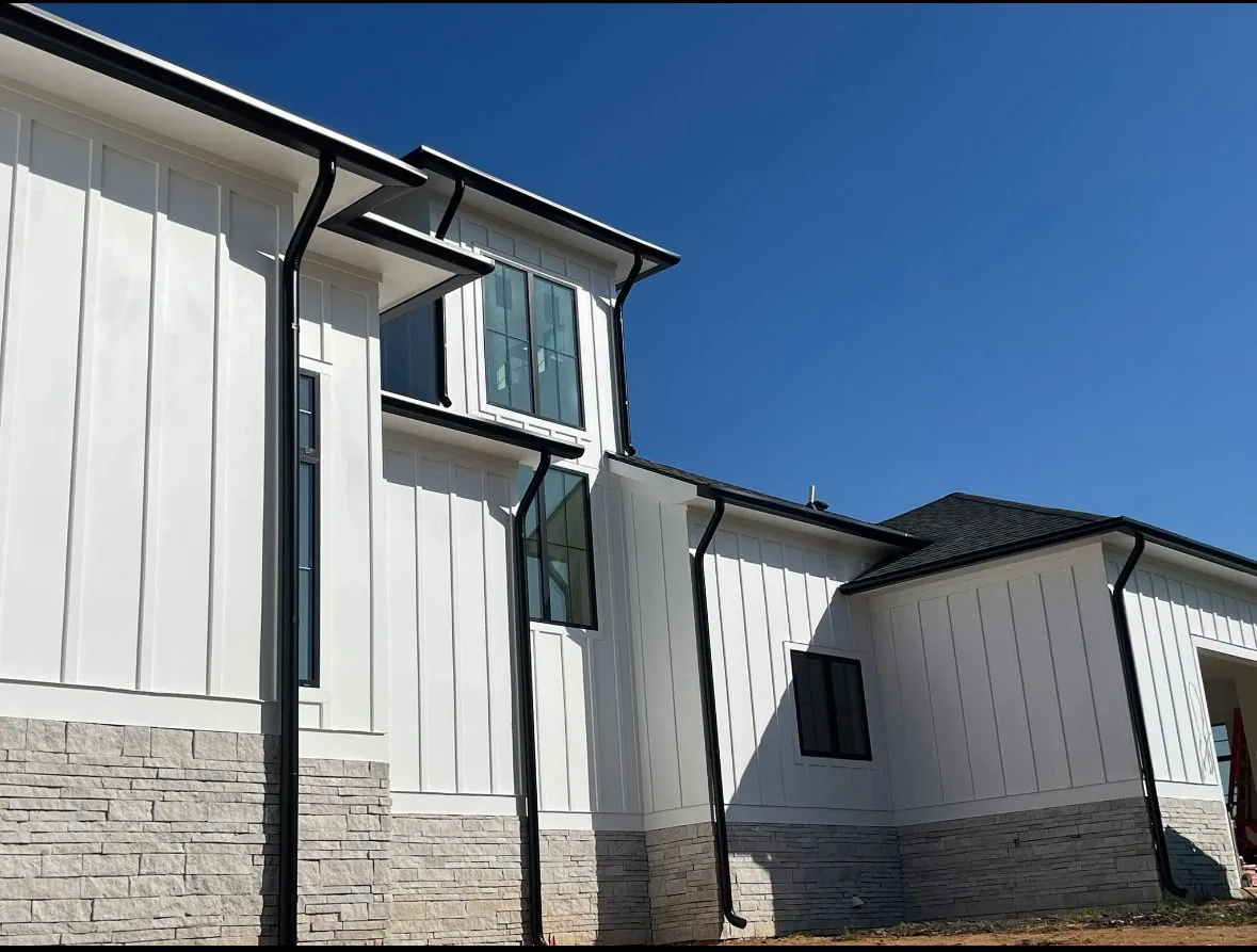 Color-matched black seamless gutters on a modern new-build home