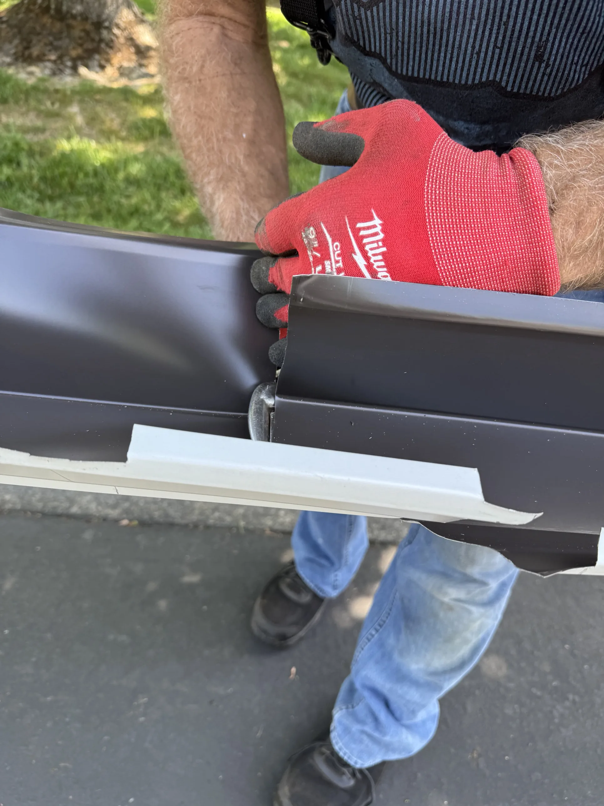 A seamless gutter corner being hand-fitted and sealed on a Sacramento home