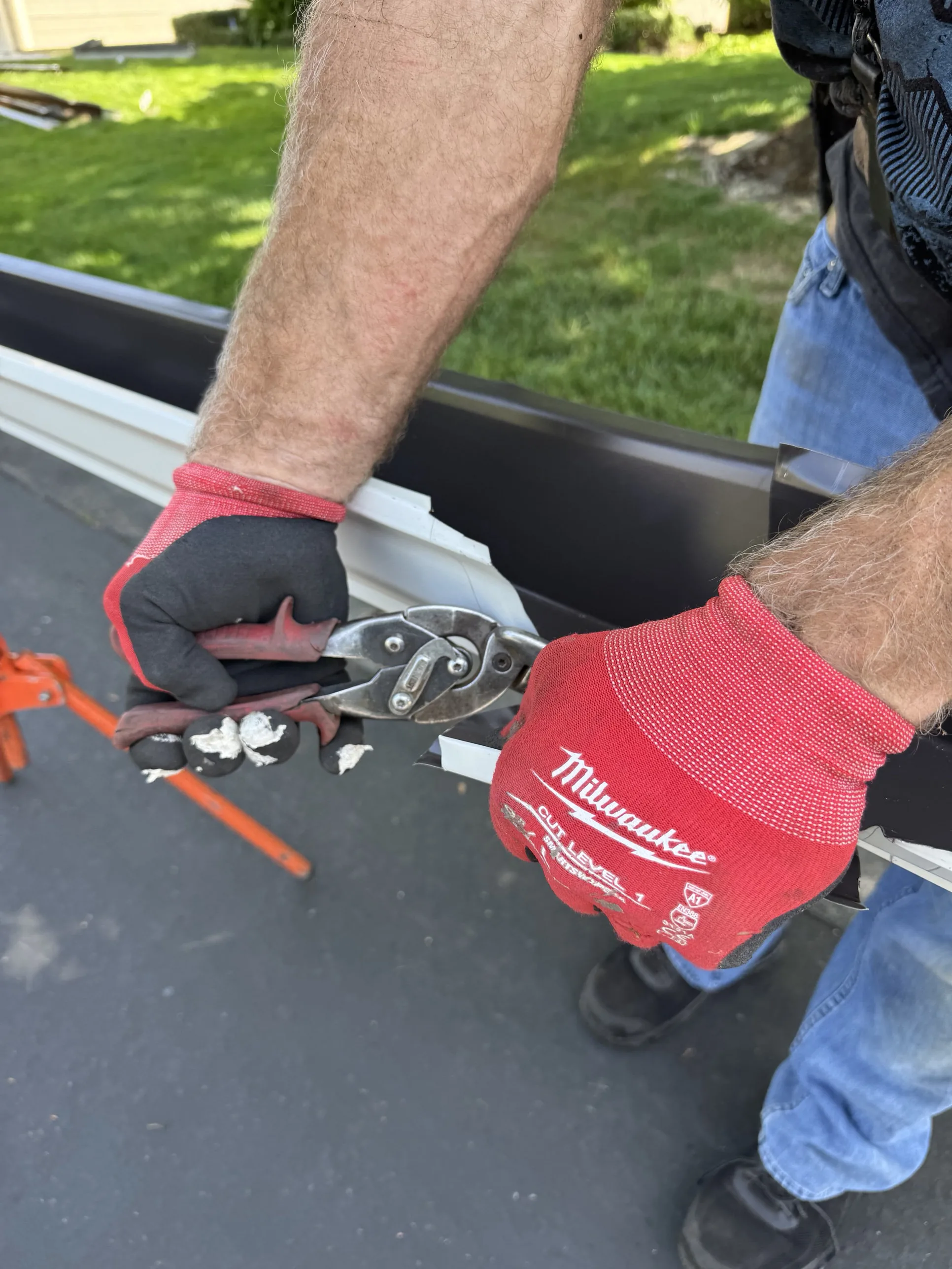 A white seamless gutter end cap crimped and sealed on a Sacramento home