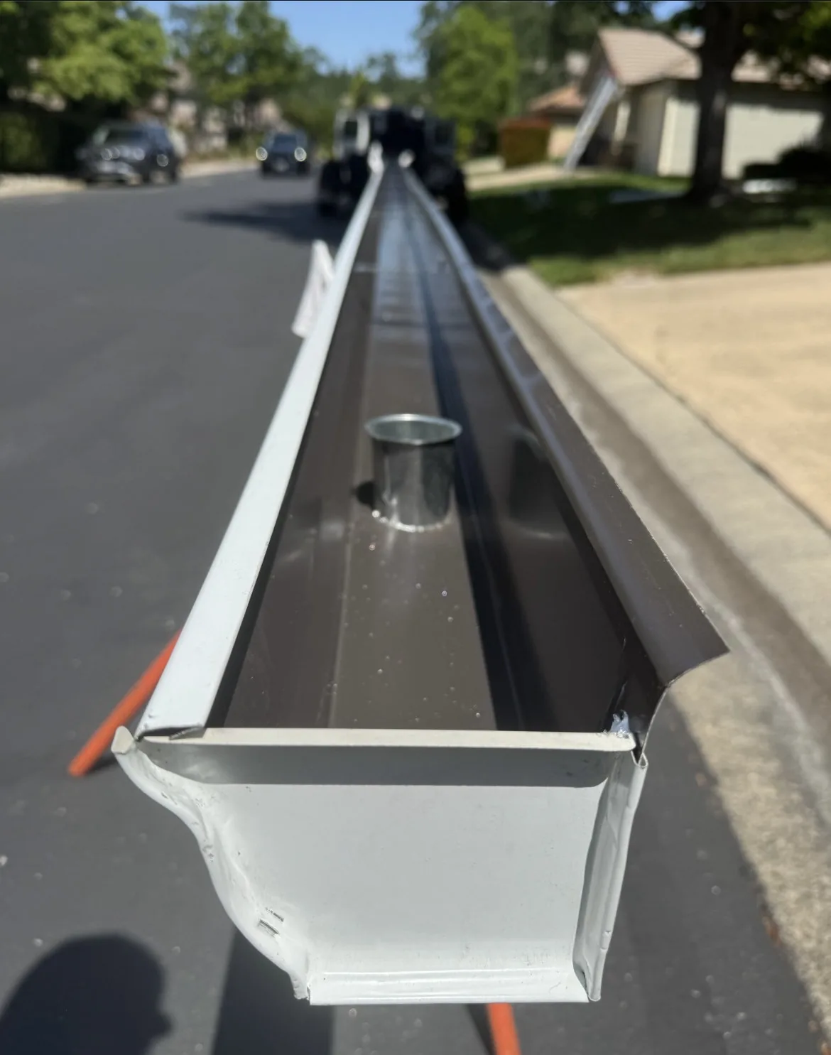 A finished seamless gutter and downspout on a home