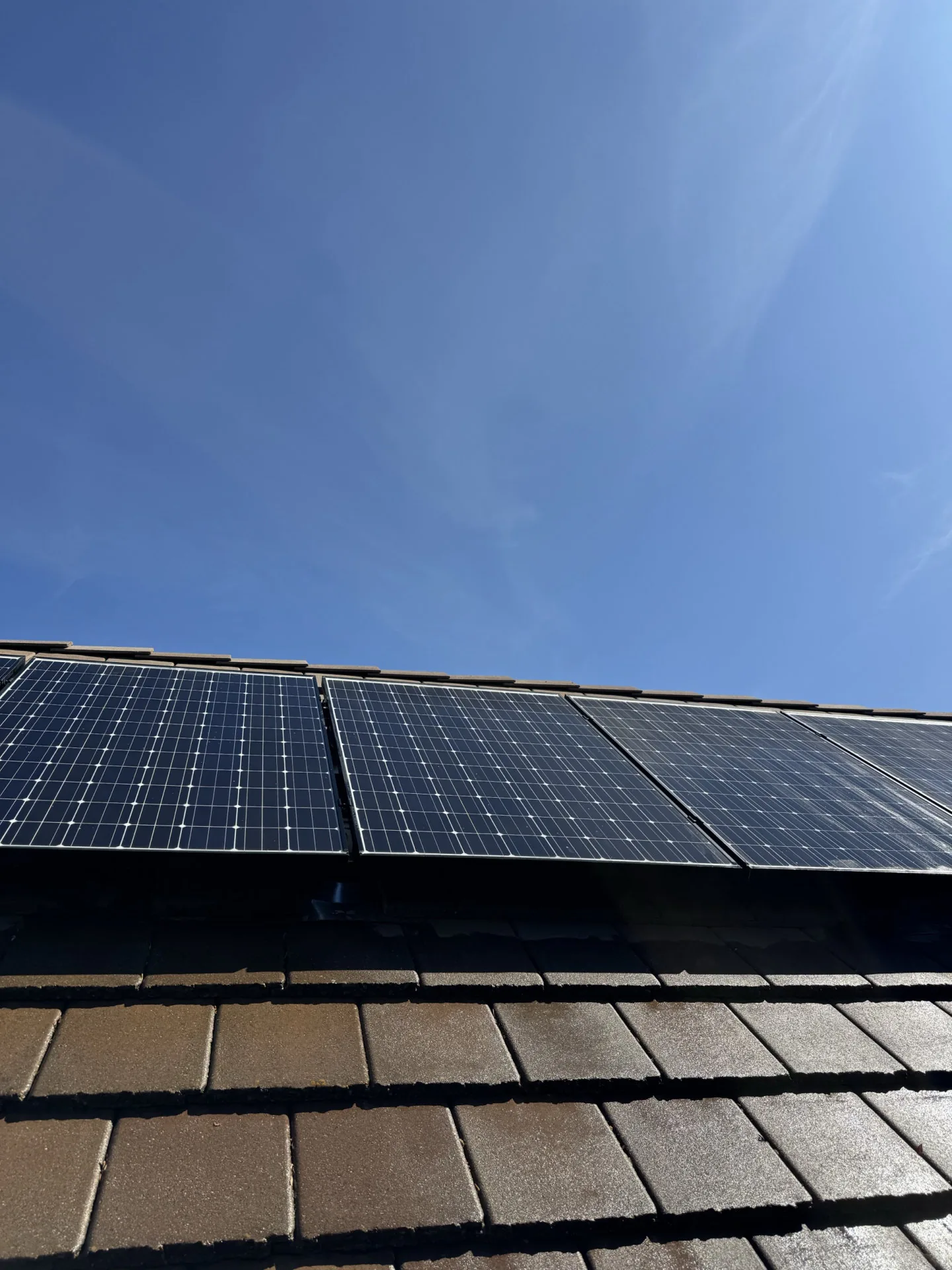 Clean solar panels on a Sacramento roof against a clear blue sky