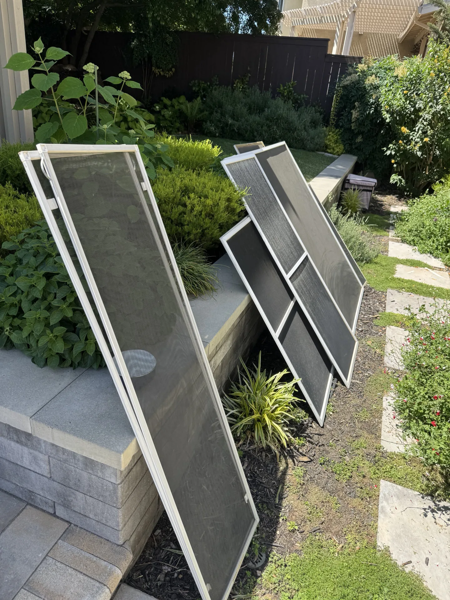 Window screens removed and leaning against a wall before cleaning