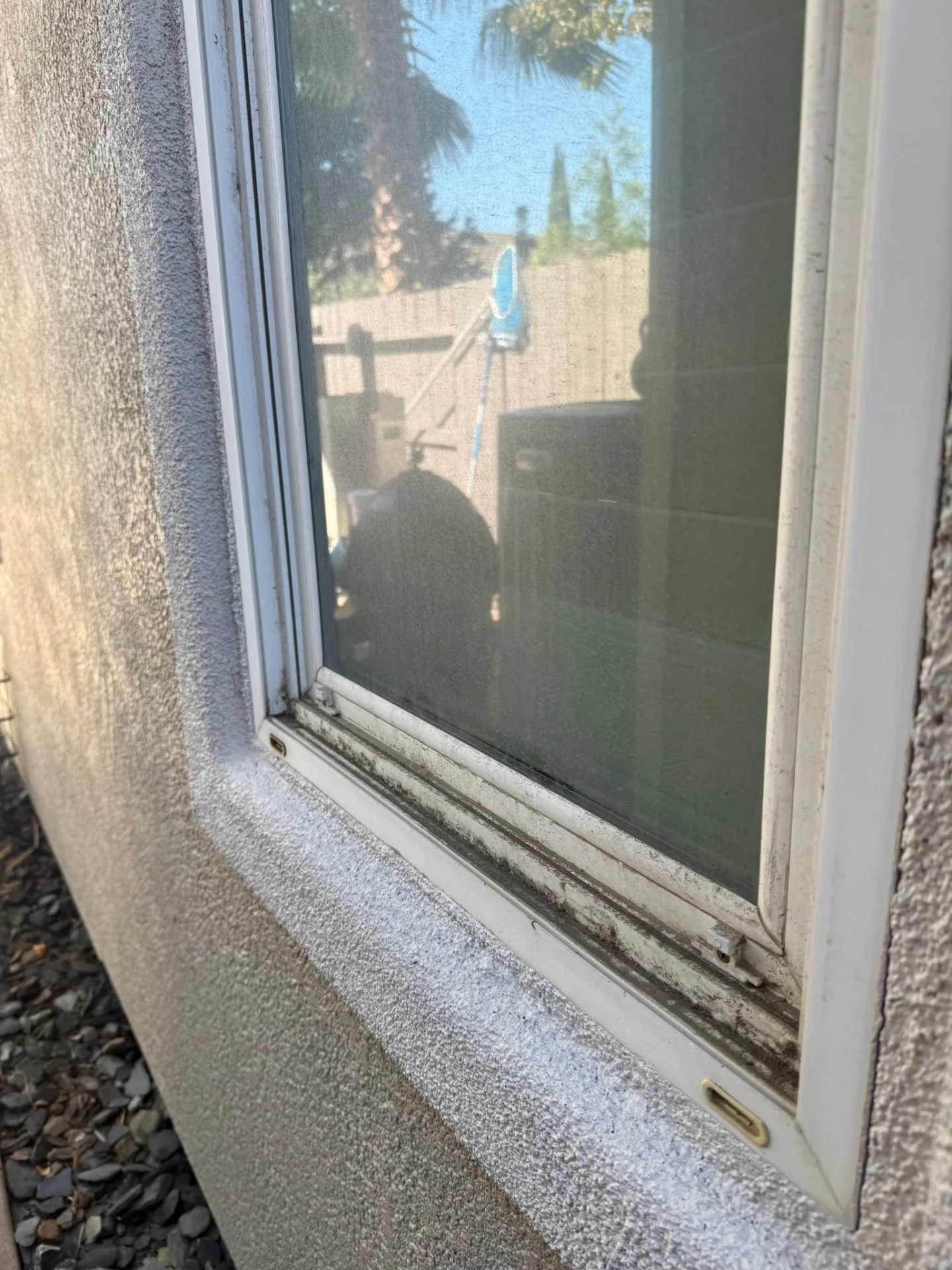 Close-up of a dust-caked window track and sill on a Sacramento home before cleaning
